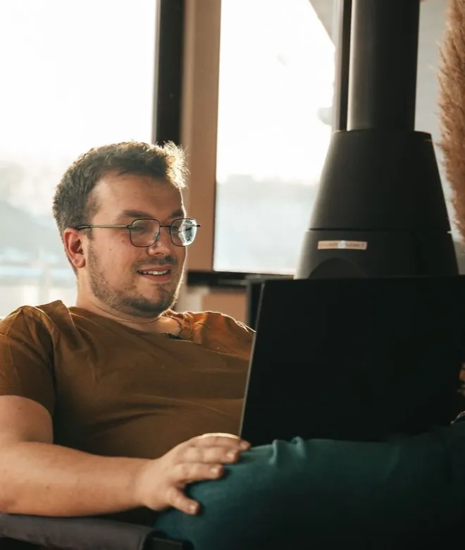 Dennis Theis am Laptop, im Gespräch über Struktur und Inhalte einer neuen Website.